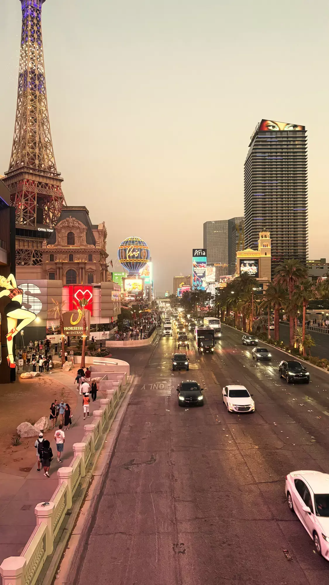 De Las Vegas Strip in de schemering met de Eiffeltoren van Paris Las Vegas, de Bellagio en verkeer op de boulevard