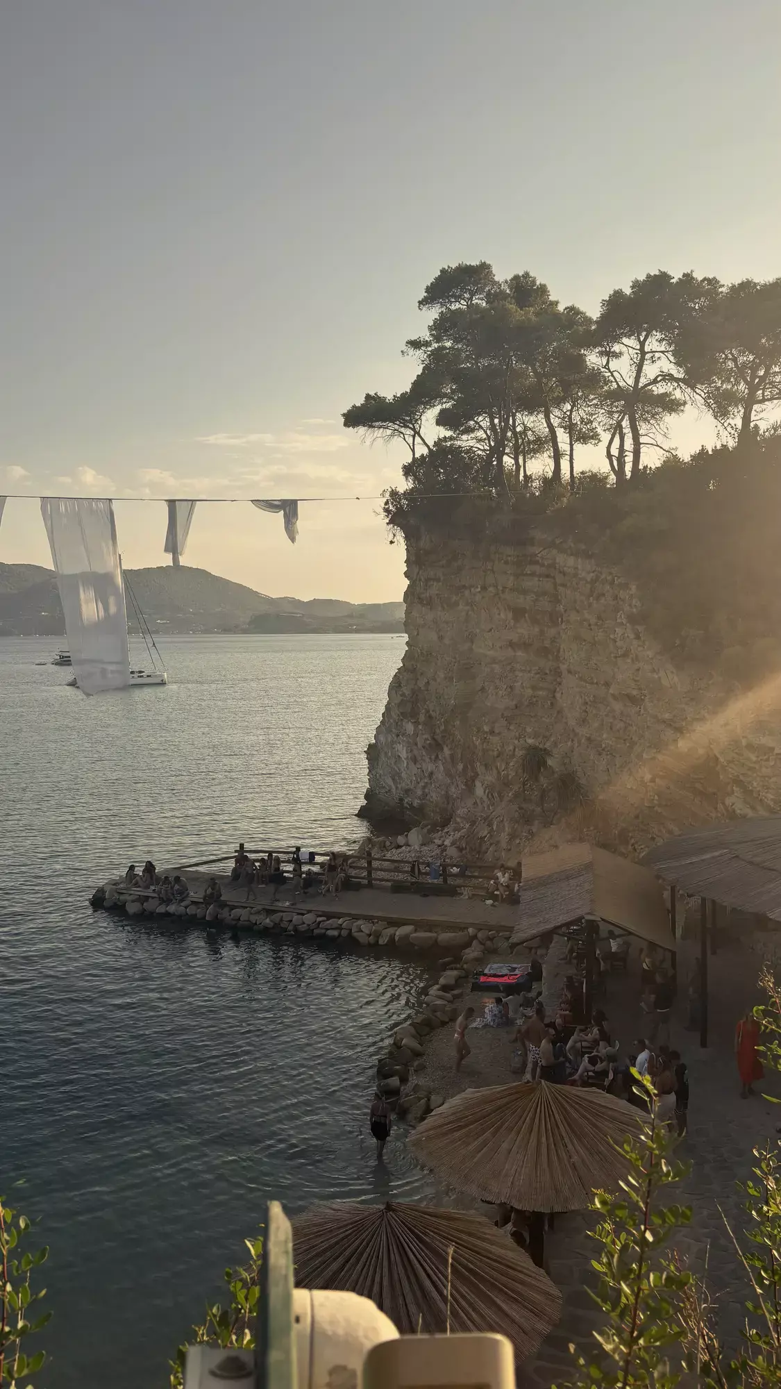 Cameo Island op Zakynthos met strandclub, parasols en wapperende witte doeken bij gouden licht