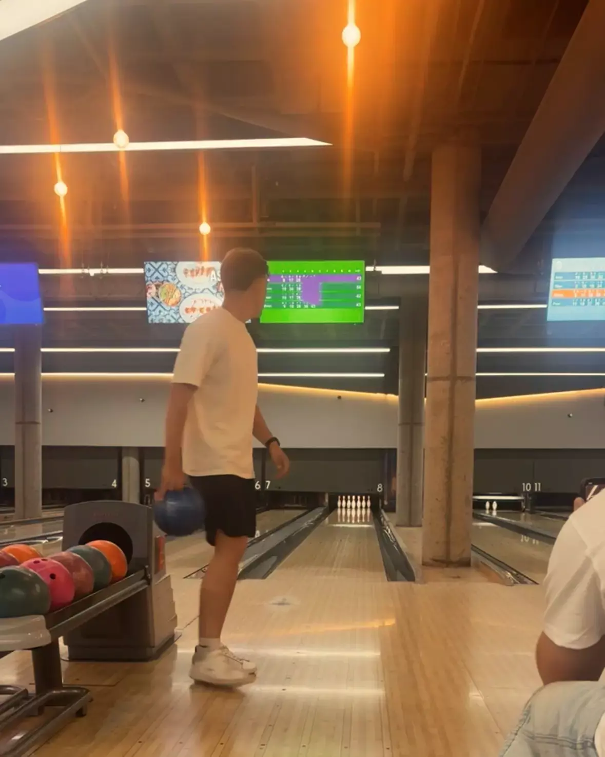 Man in wit T-shirt met blauwe bowlingbal klaar voor zijn worp op een bowlingbaan op Gran Canaria