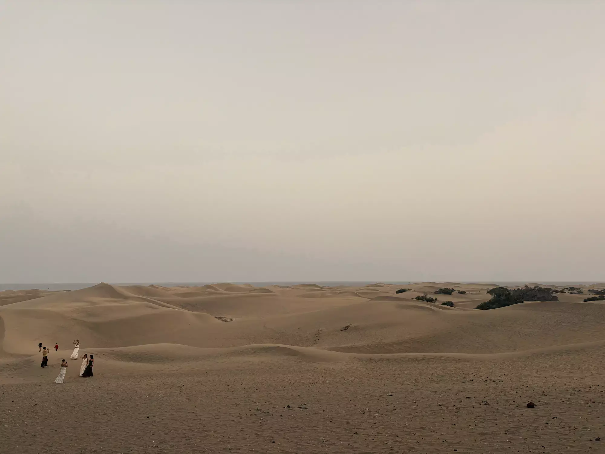 Weids duinlandschap van Maspalomas met een kleine groep mensen in het zand en de zee aan de horizon